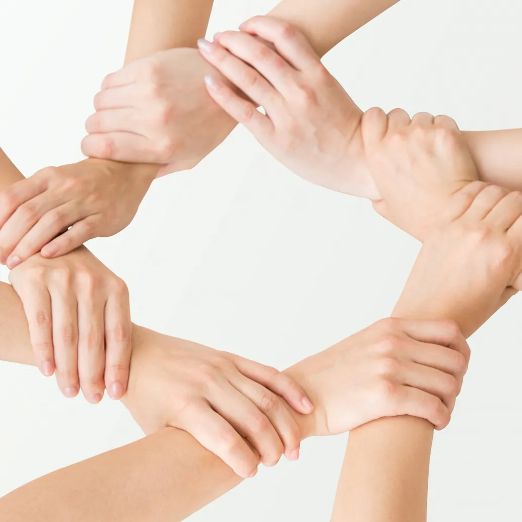 組んだたくさんの手の写真