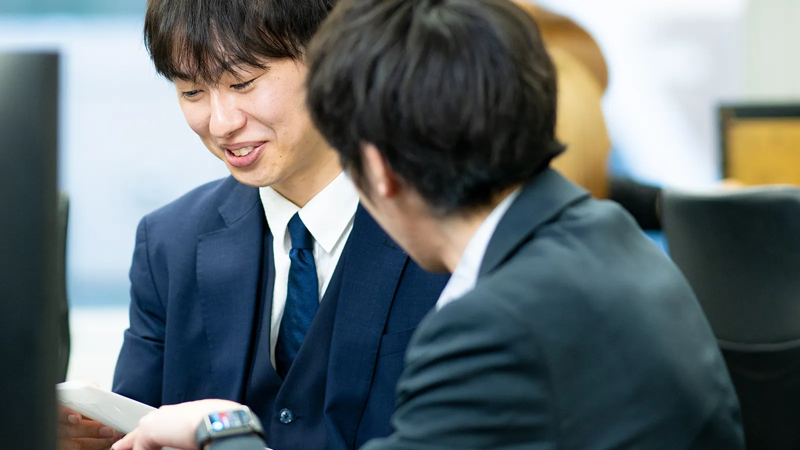 打ち合わせをする男性スタッフ2人の写真